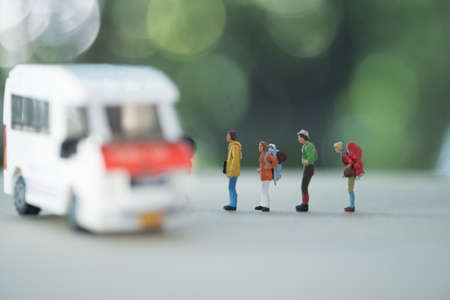 Travel and transportation Concept. Close up of group of traveler miniature figure with backpack standing with mini toy van model.の写真素材