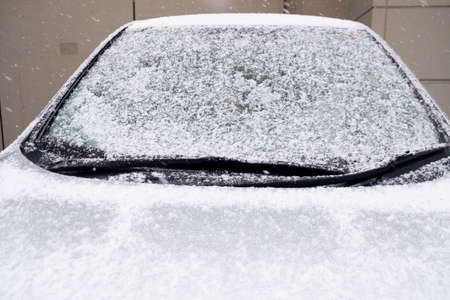 Snow cover on a car. White snowflakes. Cold weather. Snow on a car close-upの写真素材