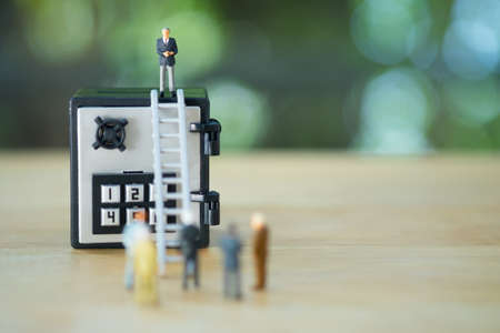 Miniature businessman standing on safety box. Concept of security asset the treatment of the precious.の写真素材