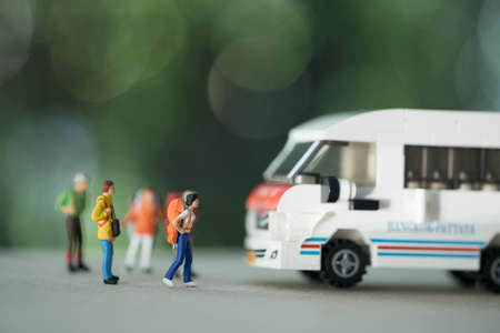 Travel and transportation Concept. Close up of group of traveler miniature figure with backpack standing with mini toy van model.の写真素材