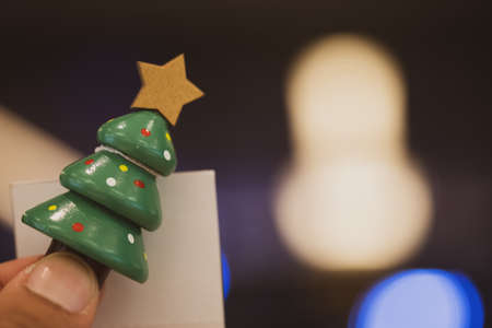 Man holding miniature Christmas tree for holiday decorationの写真素材