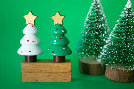 Various sizes of miniature toy artificial Christmas tree on green background. Concept of New Year, and Christmas holidayの写真素材