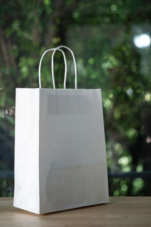 White paper bags on wood table with nature backgroundの写真素材
