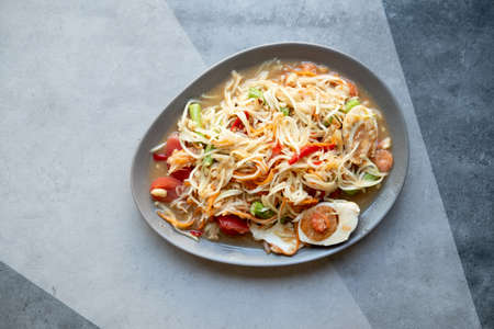 Papaya salad with salted eggs on a plate. Somtum or Thai papaya salad