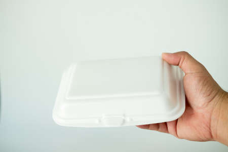 Close-up of delivery man handing of foam lunch box. Used for recycling and environment saving conceptの写真素材