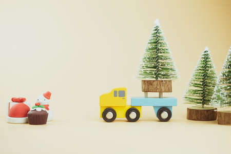 Car moves Christmas tree for decoration on yellow background