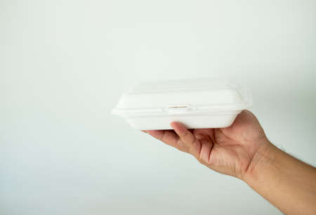 Close-up of delivery man handing of foam lunch box. Used for recycling and environment saving conceptの写真素材