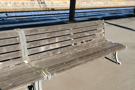 Wooden bench waiting chair for the train at the railway station platform at JR train station and snow outside in Japanの写真素材