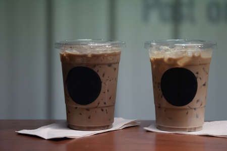 Close up of two take away plastic cup of iced mocha coffee and iced espresso on wooden tableの写真素材