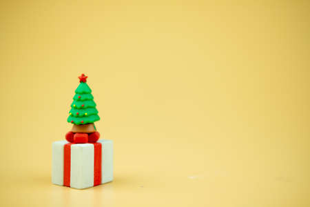 Miniature toy Christmas tree put on top of gift box. Concept of New Year and Christmas holidayの写真素材