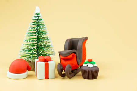 Santa claus sleigh with gift box and cupcake on yellow backgroundの写真素材