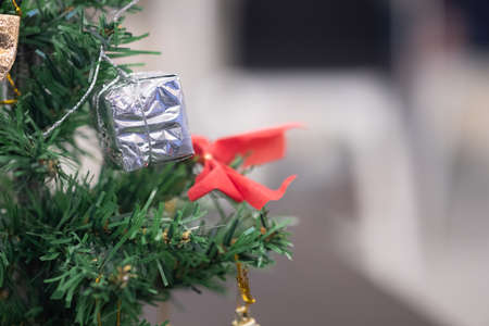 Mini gift box hanging on Christmas tree, close upの写真素材