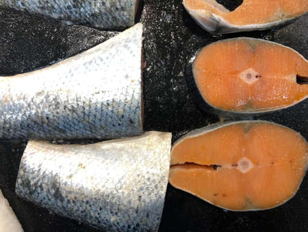 Sliced raw salmon or fresh salmon in a black tray which are sale in the supermarket.