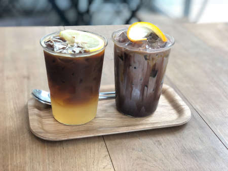 Cold coffee mix with orange juice and cold chocolate in glass on wood tableの写真素材