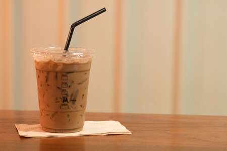 Iced espresso in take away plastic cup on the wooden table