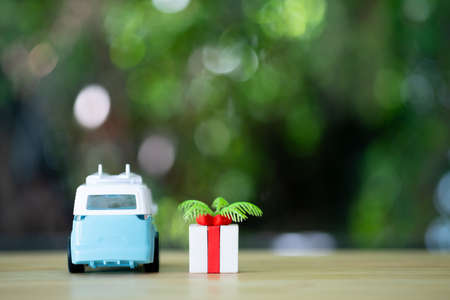 Toy blue van with gift box. Concept of tourist and concept of vacation