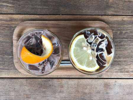 Cold coffee mix with orange juice and cold chocolate in glass on wood table
