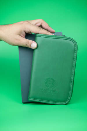 Bangkok, Thailand - January 1, 2020 : Green passport bag form Starbucks coffee shop a gift for rewards card Gold Level on green backgroundのeditorial素材