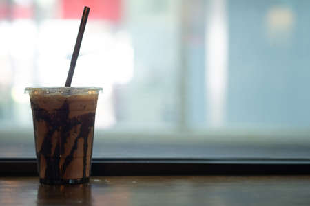 Delicious iced mocha in clear plastic glass on wood tabelの写真素材
