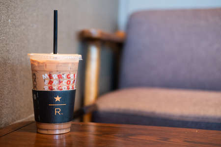 BANGKOK, THAILAND - January 1, 2020 : Starbucks coffee cold beverage in transparent plastic cup on table, famous coffee brand franchise originated in USAのeditorial素材