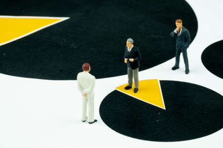 Miniature executive business man talk for joint venture standing on pie chart or graph.Concept of  joint ventureの写真素材