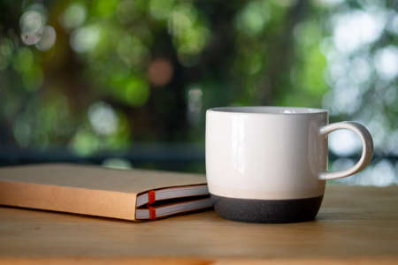 White ceramic cup and book on white table. Have a relax sunday.の写真素材