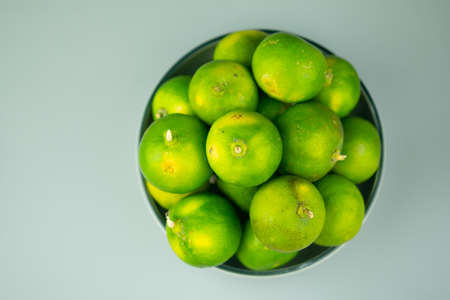Fresh green limes. Food ingredient for sour taste. Lime is a hybrid citrus fruit, which is typically...