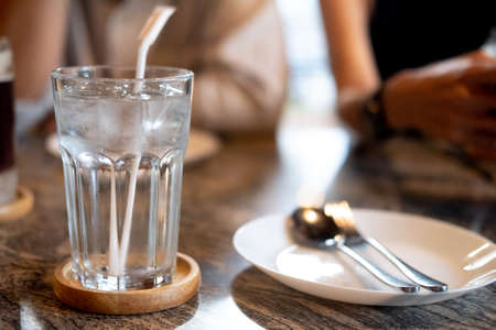 Cold water in a glass with ice on dinner table