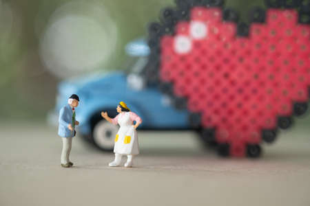 Miniature people: A senior to dating a long time of love with vintage car and heart backgroundの写真素材