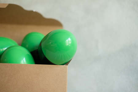 Green and black plastic toy surprise egg in brown box. Toy inside egg