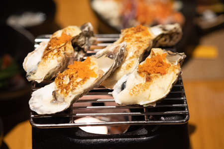 Delicious Japanese food grilled oysters with cheese and egg shrimp served on grillの写真素材