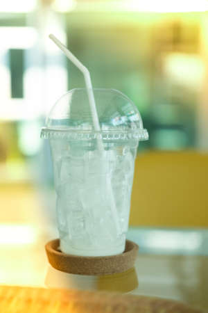 After iced drink in takeaway cup on table at coffee shopの写真素材