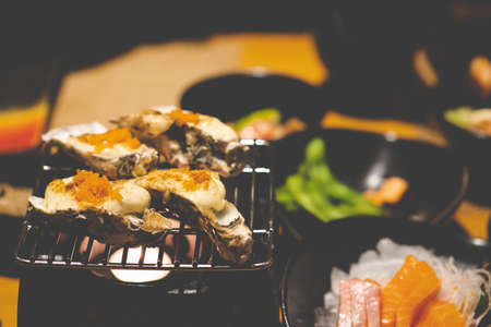 Delicious Japanese food grilled oysters with cheese and egg shrimp served on grillの写真素材