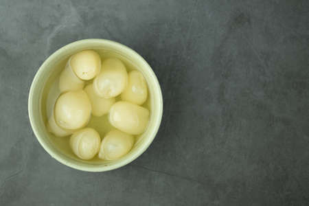 Peeled rambutan fresh in syrup in a green bowl on black backgroundの写真素材