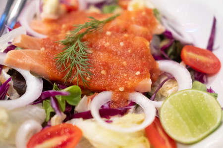 Salmon sashimi with spicy hot sauce. Japan salmon sashimi and Thai herb in Japanese restaurant.
