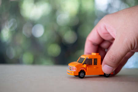 Child playing with a orange toy truck on tableの写真素材