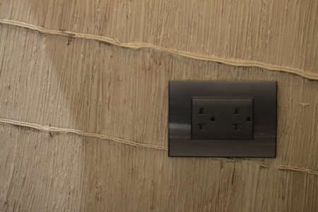Black electrical outlet on wall in home at Thailand