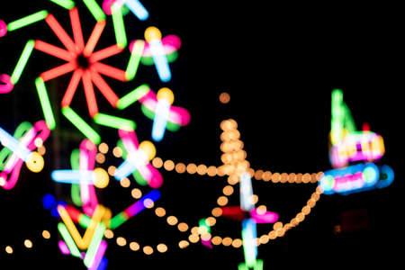 Blur colors light beam of fluorescent light colorful in festival temple fair night background, lighting beam in carnival colorful light shine show of thai temple fair festival color bokehの写真素材