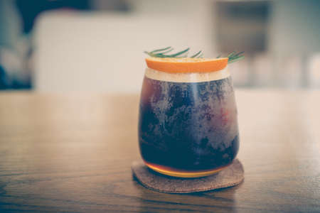 Glass of espresso shot mixed with orange juice on wood table. Refreshing summer drink conceptの写真素材