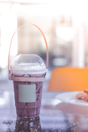 Iced coffee mocha in a plastic cup with handle make from bamboo carry at coffee shop. Concept of...