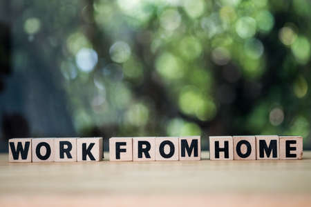 Wooden blocks with the word work from home on wood table with nature blur backgroundの写真素材
