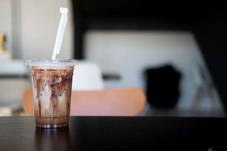 Delicious iced mocha in clear plastic glass, showing the texture of chocolate sauce in glass