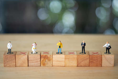 Miniature people stand on wood block keeping distance for infection risk and disease for prevent...
