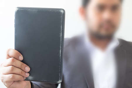 Young hipster businessman holding tablet in hands. Close up
