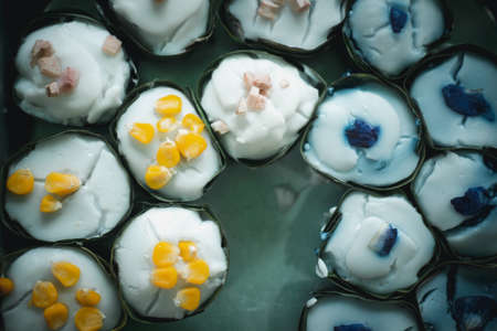 Thai desserts wrapped in pandan leaves with various topping (Tako)