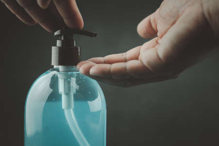 Man use hand sanitizer alcohol gel cleaning protect from Coronavirus, COVID-19 on black backgroundの写真素材
