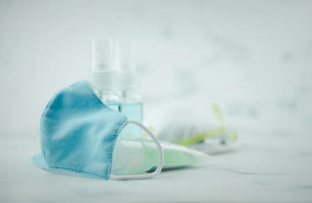 Blue cotton mask use reusable put with hand sanitizer and hand disinfectant alcohol spray. Coronavirus prevention through antibacterial hygieneの写真素材