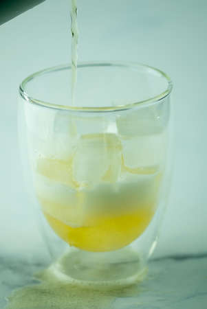 Pour beer into glass with double walls. Close up
