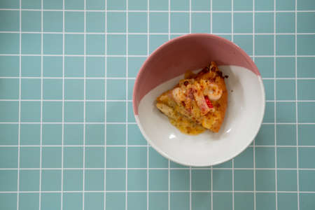 Hot pizza slice in bowl. Top view