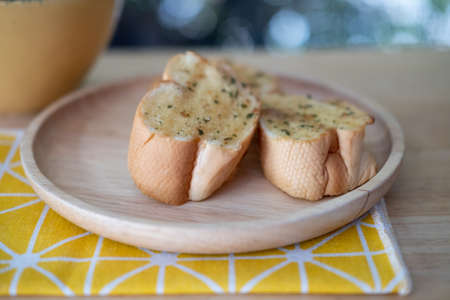 Close up of a wooden dish of garlic breadの写真素材